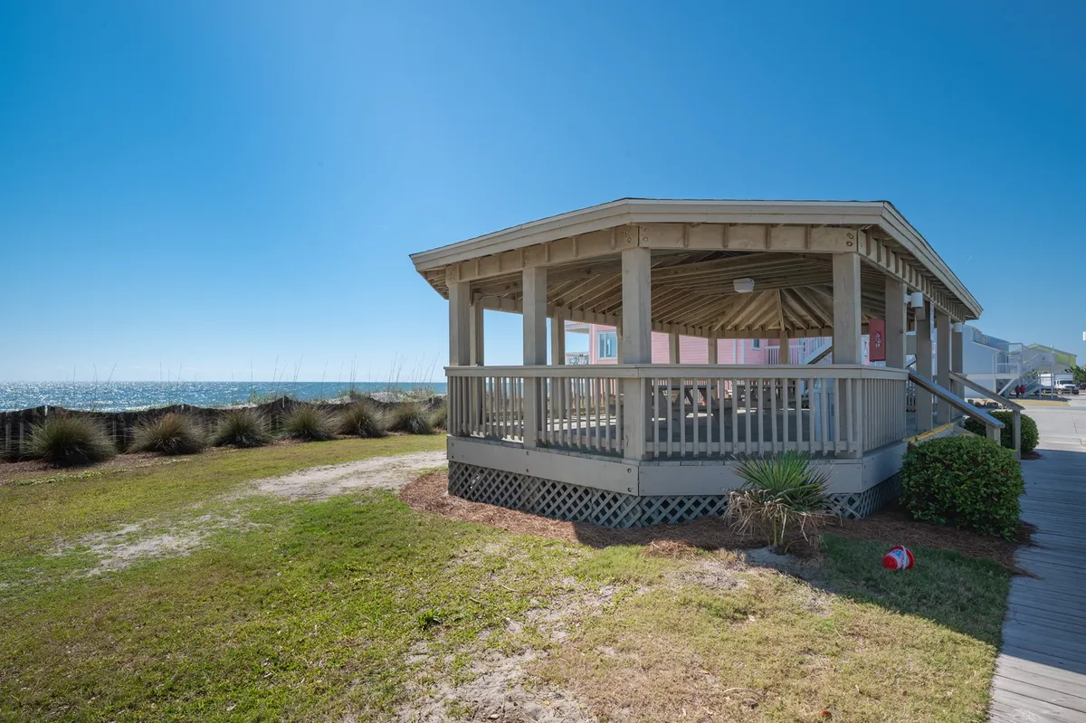 A picturesque beach gazebo overlooking the ocean, surrounded by lush greenery. The setting is peaceful and ideal for picnics, relaxing, or simply enjoying the views after a day of adventure.